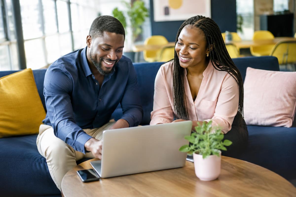 A man and a woman collaborating warmly over a laptop